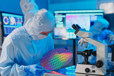A worker in semiconductor manufacturing handles a wafer produced in a ESD coated environment